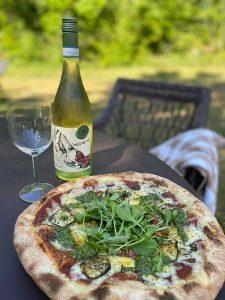 Stenugnspizza och ett glas vin mitt i naturen